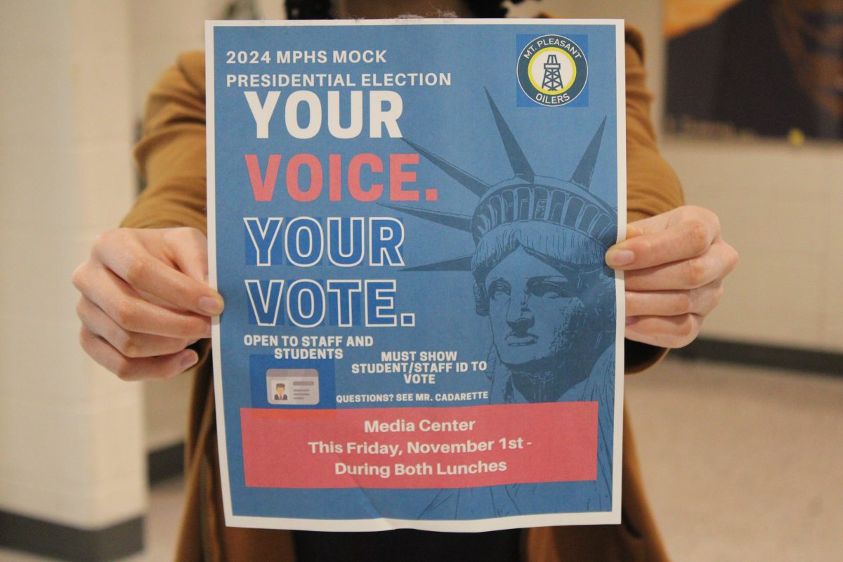 Student holds the mock election poster. 